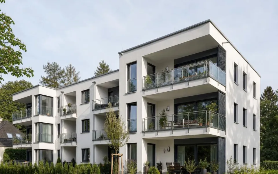 Dreigeschossiges Mehrfamilienhaus mit verglasten Balkonen als Neubau für Kapitalanlegende